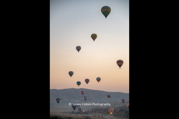 Hot Air Balloons rising at sunrise from the Observation Deck in Goreme, Cappadocia, Turkey